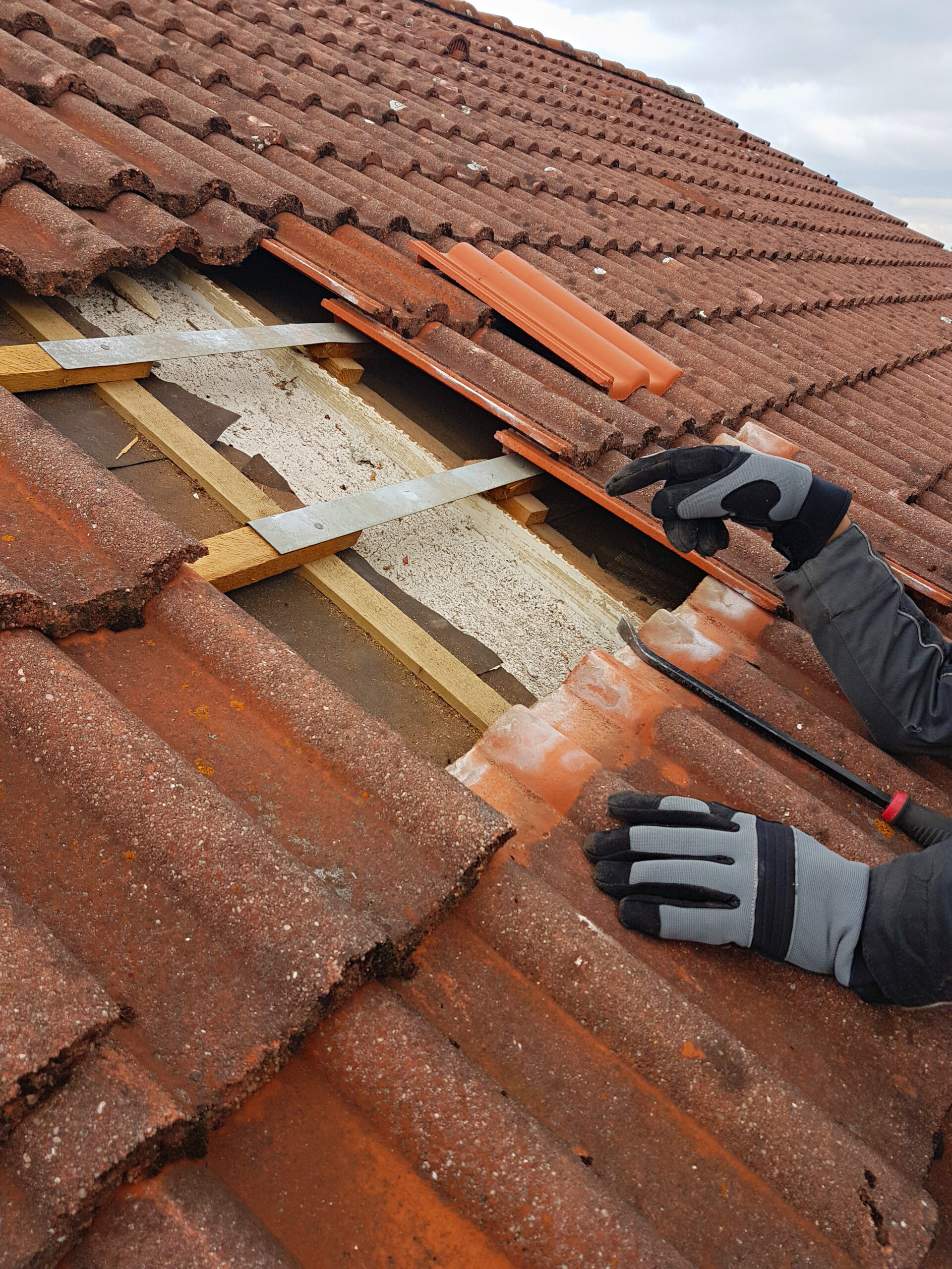 man replaces broken roof shingles on the rooftop with new ones. closeup shot Rachat de prêt hypothécaire - Conseils